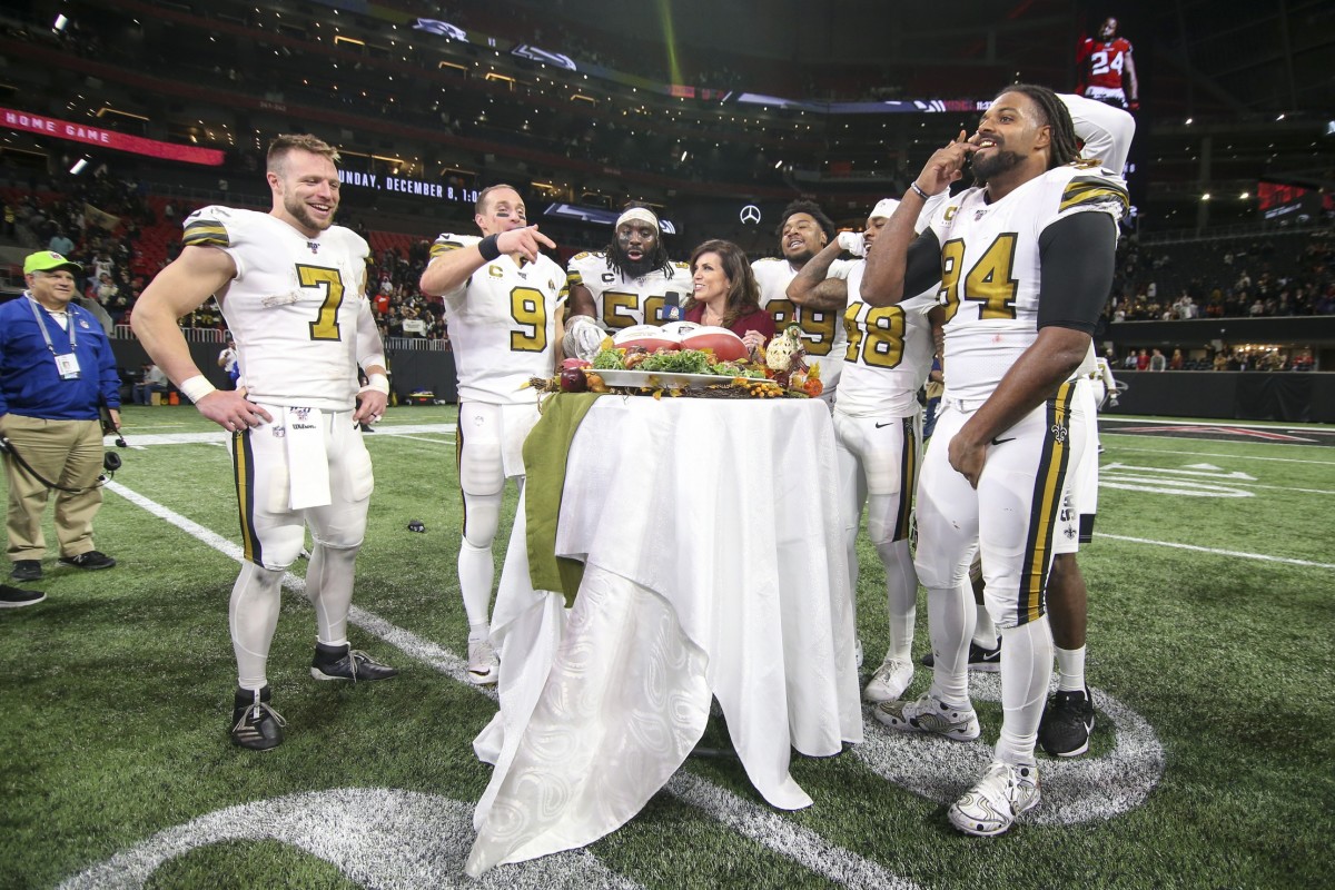 Nov 28, 2019; Atlanta, GA, USA; New Orleans Saints quarterback Taysom Hill (7) and quarterback Drew Brees (9) and outside linebacker Demario Davis (56) and defensive tackle Shy Tuttle (99) and defensive back J.T. Gray (48) and defensive end Cameron Jordan (94) talk to sideline reporter Michele Tafoya after a game against the Atlanta Falcons at Mercedes-Benz Stadium. Mandatory Credit: Brett Davis-USA TODAY Sports
