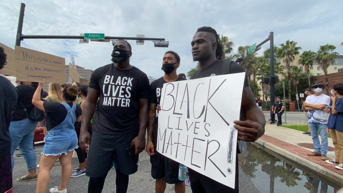 Jaguars players (L-R) Rodney Gunter, Keelan Cole and Ronnie Harrison declare Black lives matter during Tuesday's march. Photo credit: Kassidy Hill 