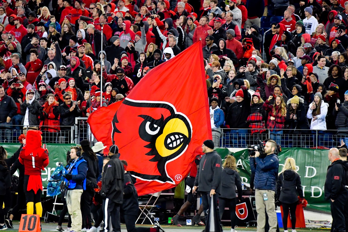 Louisville Cardinals quarterback Micale Cunningham (3) (not seen) runs down the sideline with the team flag late during the second half of the 2019 Music City Bowl against the Mississippi State Bulldogs at Nissan Stadium.