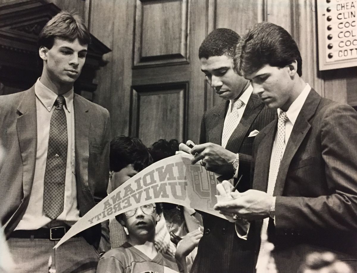 Todd Meier (left), Daryl Thomas and Steve Alford (right) sign pennant for Todd Dovrak, 9, during House visit in April 1987.