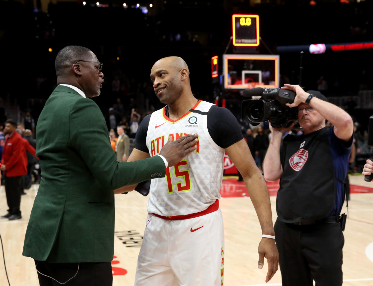 Mar 11, 2020; Atlanta, Georgia, USA; NBA Hall of Fame player Dominique Wilkins (left) greets Atlanta Hawks guard Vince Carter (15) after a Hawks overtime loss to the New York Knicks at State Farm Arena. Mandatory Credit: Jason Getz-USA TODAY Sports