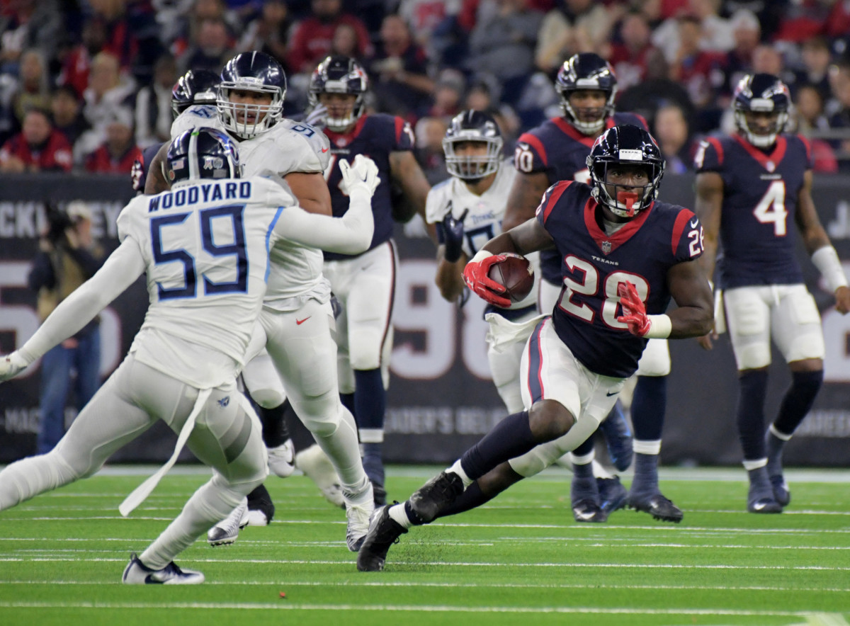 Texans running back Alfred Blue (28) runs around Titans inside linebacker Wesley Woodyard (59) during a 2018 game.
