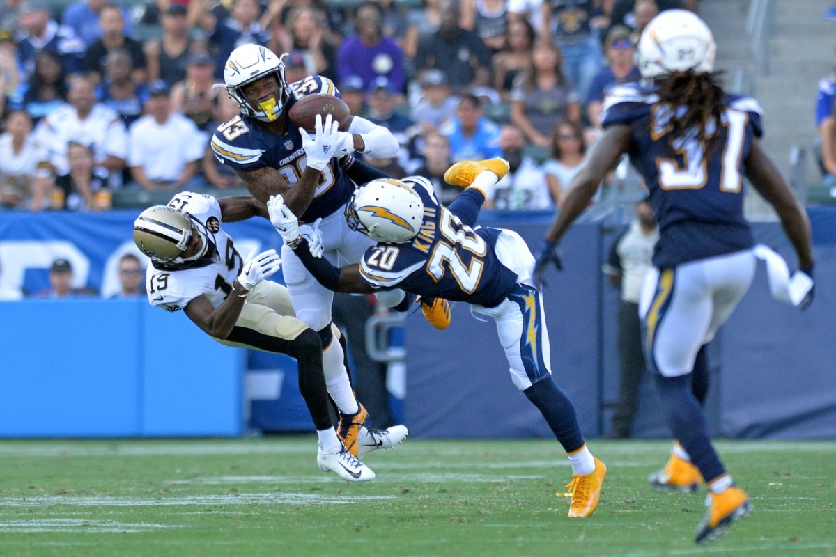 Aug 25, 2018; Carson, CA, USA; Los Angeles Chargers defensive back Derwin James (33) intercepts a pass intended for New Orleans Saints wide receiver Ted Ginn (19) and defensive back Desmond King (20) assists during the first quarter at StubHub Center. Mandatory Credit: Jake Roth-USA TODAY Sports