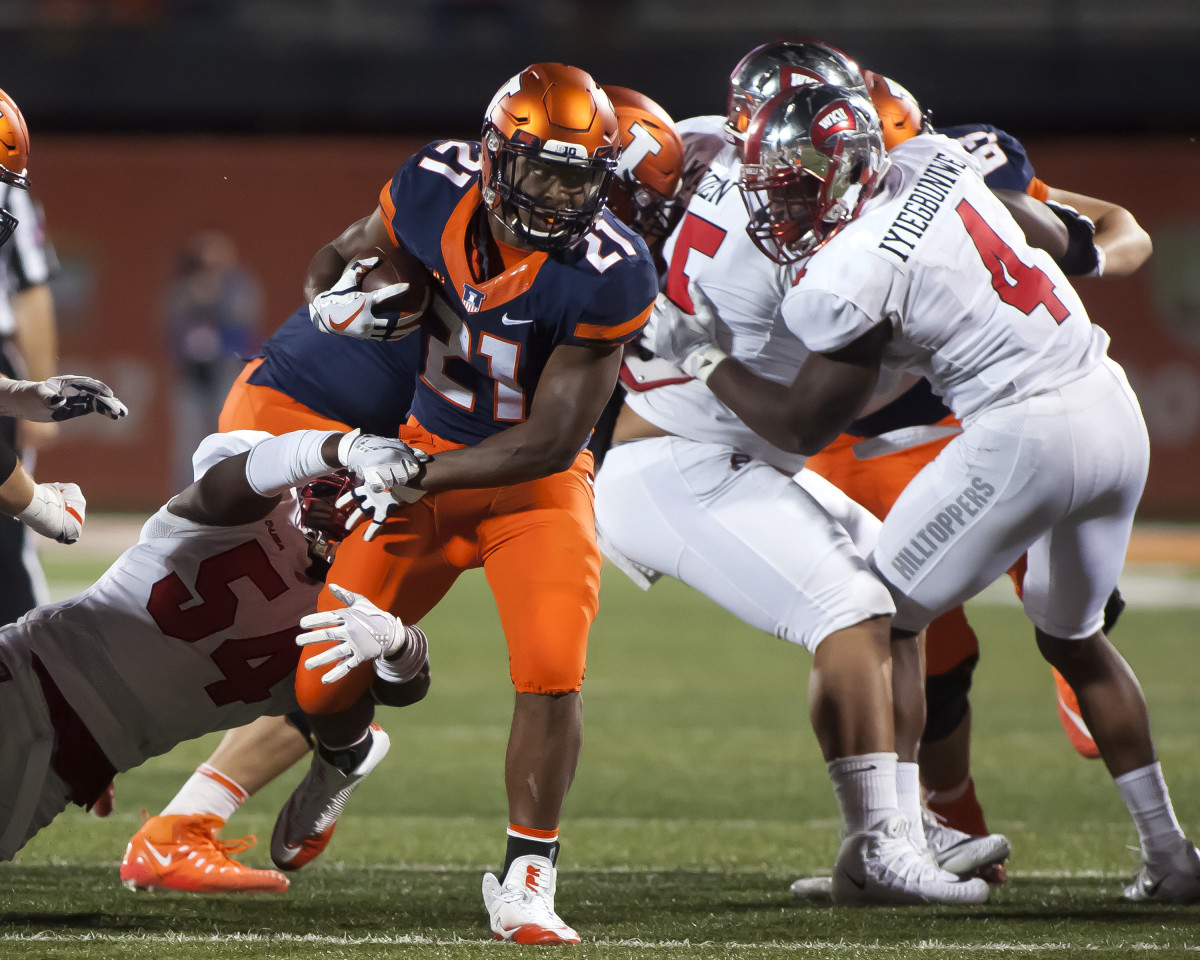 Illinois Fighting Illini running back Ra'Von Bonner (21) escapes from Western Kentucky Hilltoppers linebacker Daeshawn Bertram (54) during the fourth quarter of a 2017 game at Memorial Stadium in Champaign, Ill.