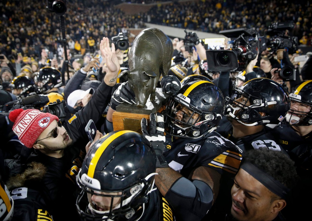 Iowa players carry the Floyd of Rosedale trophy after last season's win over Minnesota. (Bryon Houlgrave/Des Moines Register for USA Today Sports)