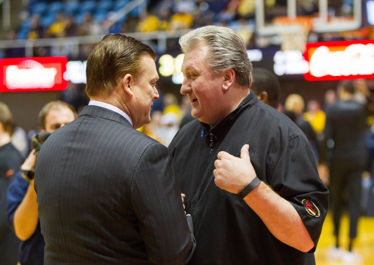 West Virginia Mountaineers head coach Bob Huggins (right) and Oklahoma State Cowboys head coach Brad Underwood (left) speak before the tip at WVU Coliseum.