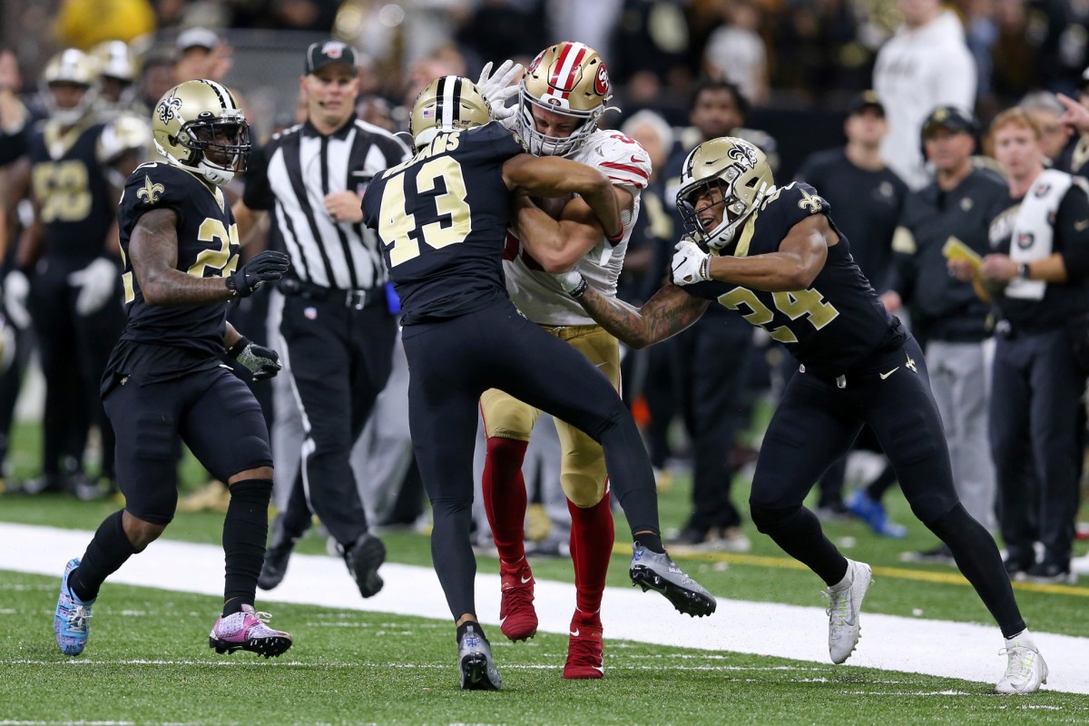 Dec 8, 2019; New Orleans, LA, USA; San Francisco 49ers tight end George Kittle (85) is defended by New Orleans Saints free safety Marcus Williams (43) and defensive back Chauncey Gardner-Johnson (22) and strong safety Vonn Bell (24) after a reception late in the fourth quarter at the Mercedes-Benz Superdome. The 49ers won, 48-46. Mandatory Credit: Chuck Cook-USA TODAY Sports