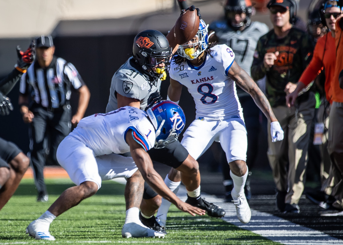Oklahoma State Cowboys safety Kolby Harvell-Peel (31) is tackled after intercepting the ball by Kansas Jayhawks running back Pooka Williams Jr. (1) during the second half at Boone Pickens Stadium.