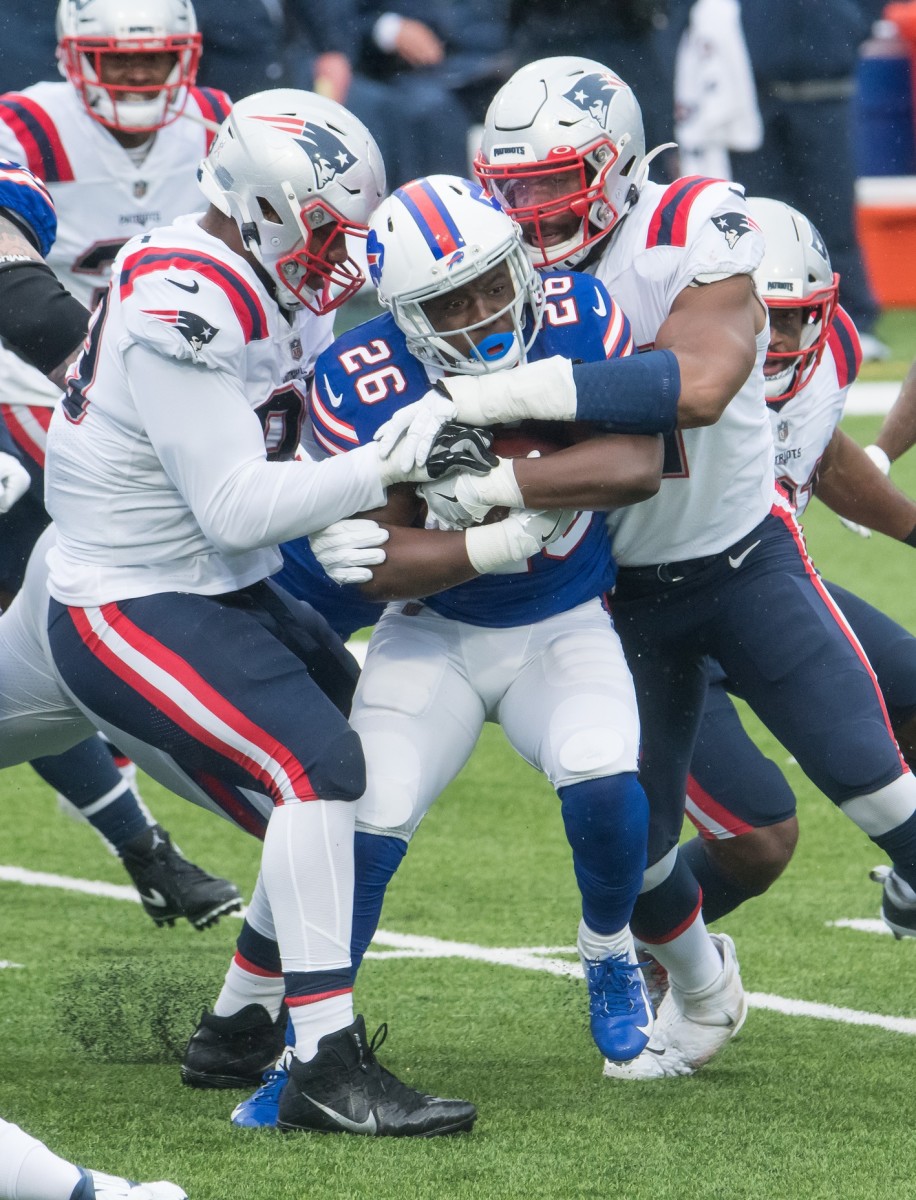 Buffalo Bills running back Devin Singletary (26) is stood up for a tackle by the New England Patriots and linebacker Ja'Whaun Bentley (right). Mandatory Credit: Mark Konezny-USA TODAY Sports