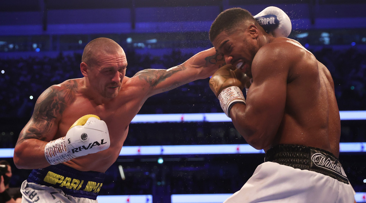 Oleksandr Usyk punches as Anthony Joshua ducks during the Heavyweight Title Fight between Anthony Joshua and Oleksandr Usyk at Tottenham Hotspur Stadium on September 25, 2021 in London, England.