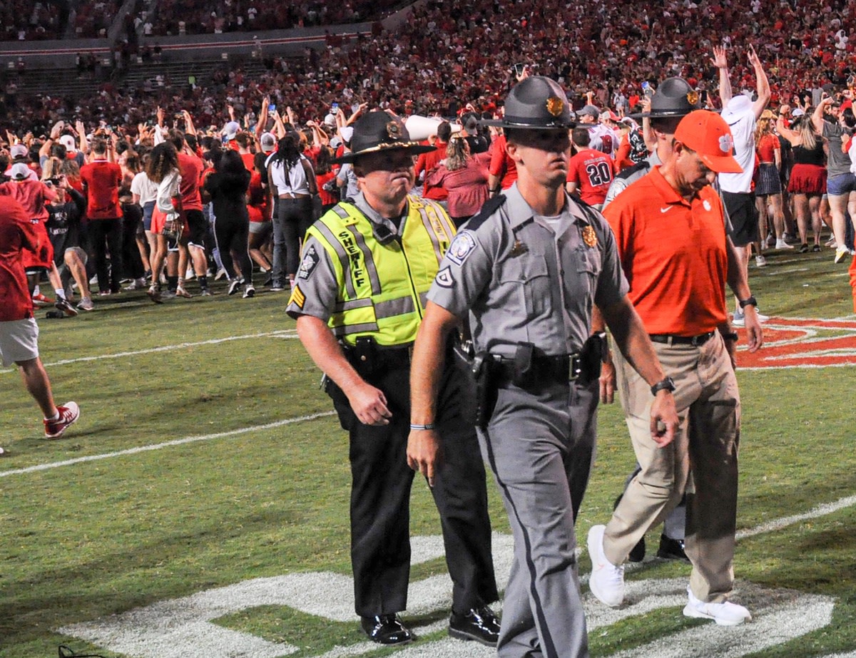 Clemson head coach Dabo Swinney walks by NC State celebrating their 27-21 win in two overtimes game at Carter-Finley Stadium in Raleigh, N.C., September 25, 2021.