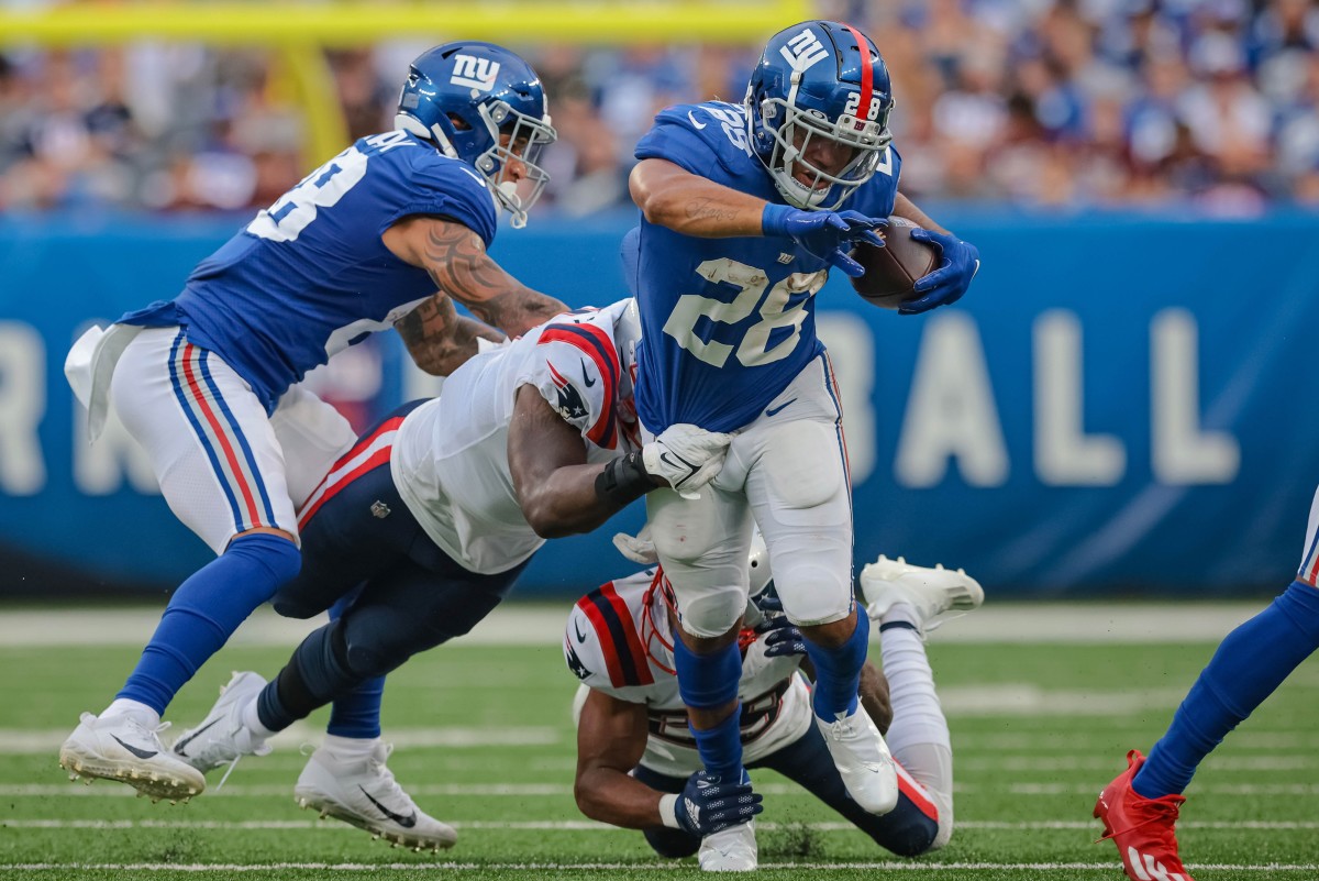 Aug 29, 2021; East Rutherford, New Jersey, USA; New York Giants running back Devontae Booker (28) carries the ball as New England Patriots linebacker Ja'Whaun Bentley (8) tackles during the first half at MetLife Stadium.