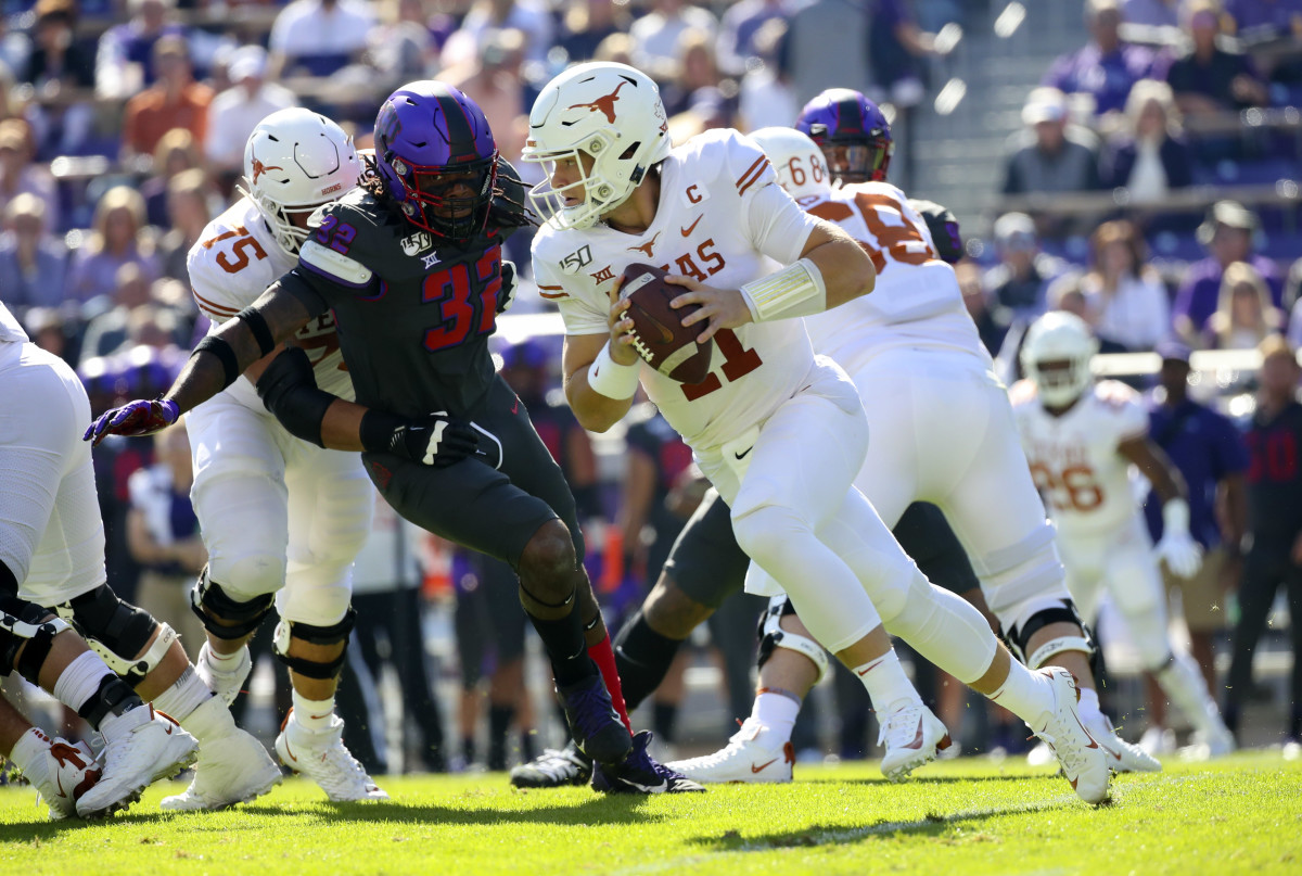 Oct 26, 2019; Fort Worth, TX, USA; Texas Longhorns quarterback Sam Ehlinger (11) looks to throws as TCU Horned Frogs defensive end Ochaun Mathis (32) chases during the first quarter at Amon G. Carter Stadium.