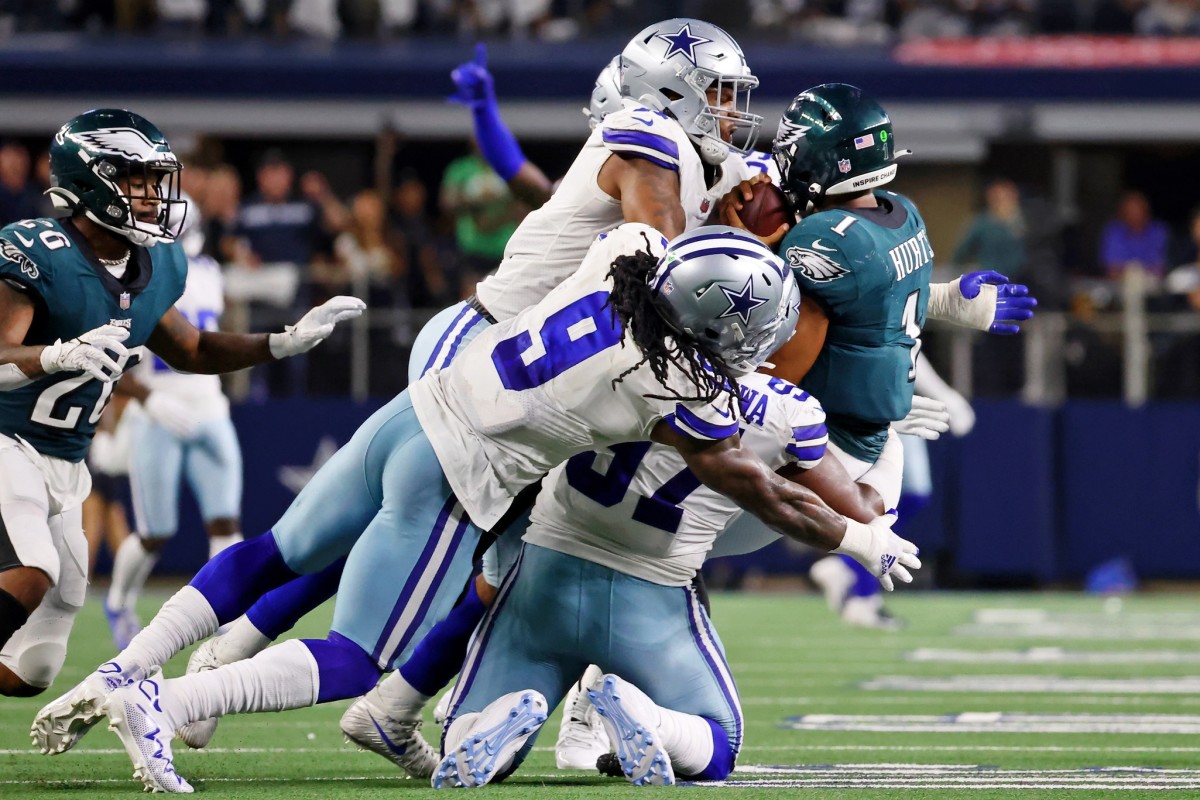 Sep 27, 2021; Arlington, Texas, USA; Philadelphia Eagles quarterback Jalen Hurts (1) is tackled by Dallas Cowboys linebacker Micah Parsons (top) and middle linebacker Jaylon Smith (left) and defensive tackle Osa Odighizuwa (bottom) during the fourth quarter at AT&T Stadium.