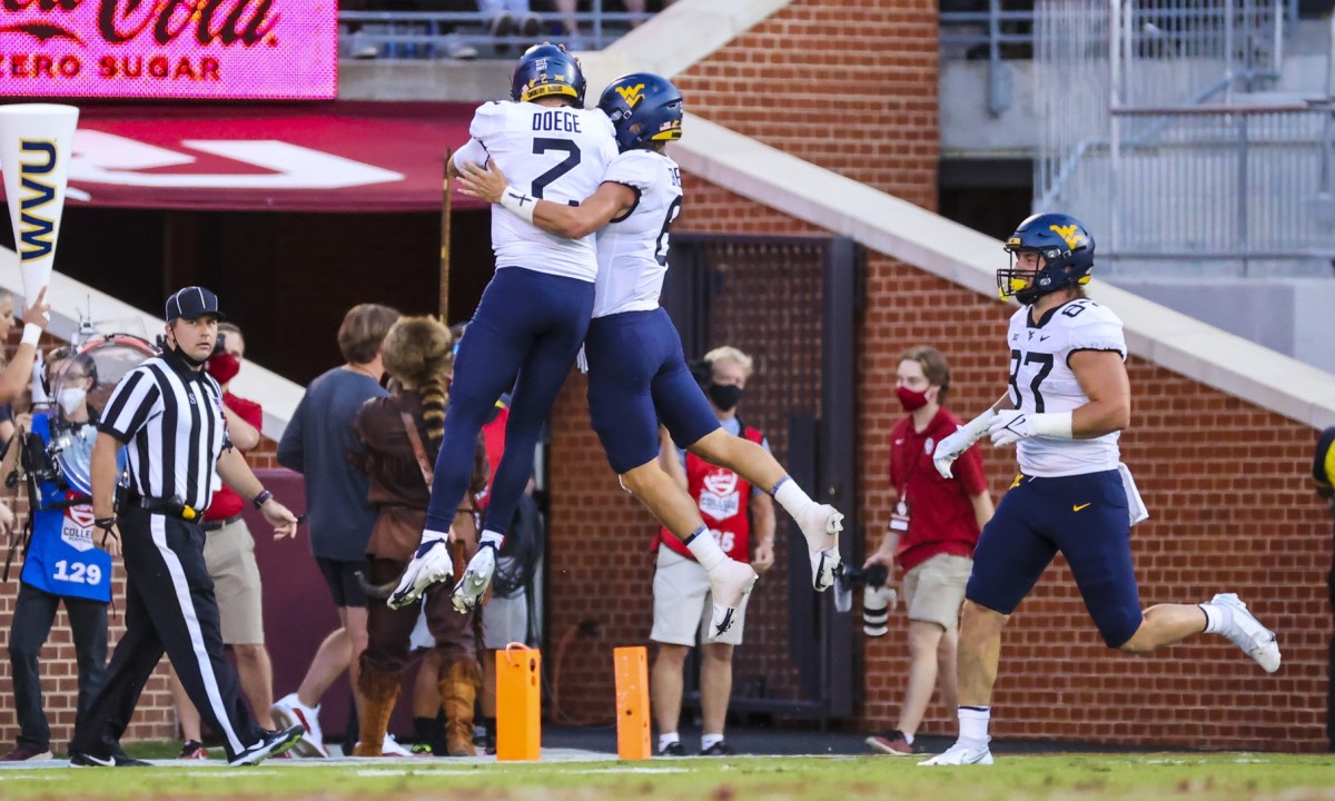 Sep 25, 2021; Norman, Oklahoma, USA; West Virginia Mountaineers quarterback Garrett Greene (6) celebrates with quarterback Jarret Doege (2) after scoring a touchdown during the first quarter against the Oklahoma Sooners at Gaylord Family-Oklahoma Memorial Stadium.