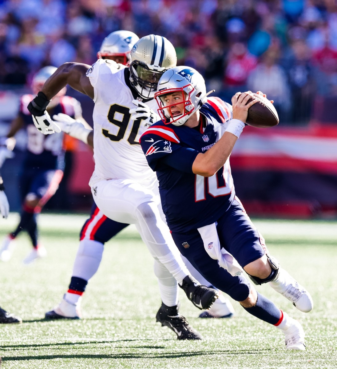 New England Patriots quarterback Mac Jones (10) scrambles from New Orleans Saints Tanoh Kpassagnon (90). Mandatory Credit: Stephen Lew-USA TODAY Sports