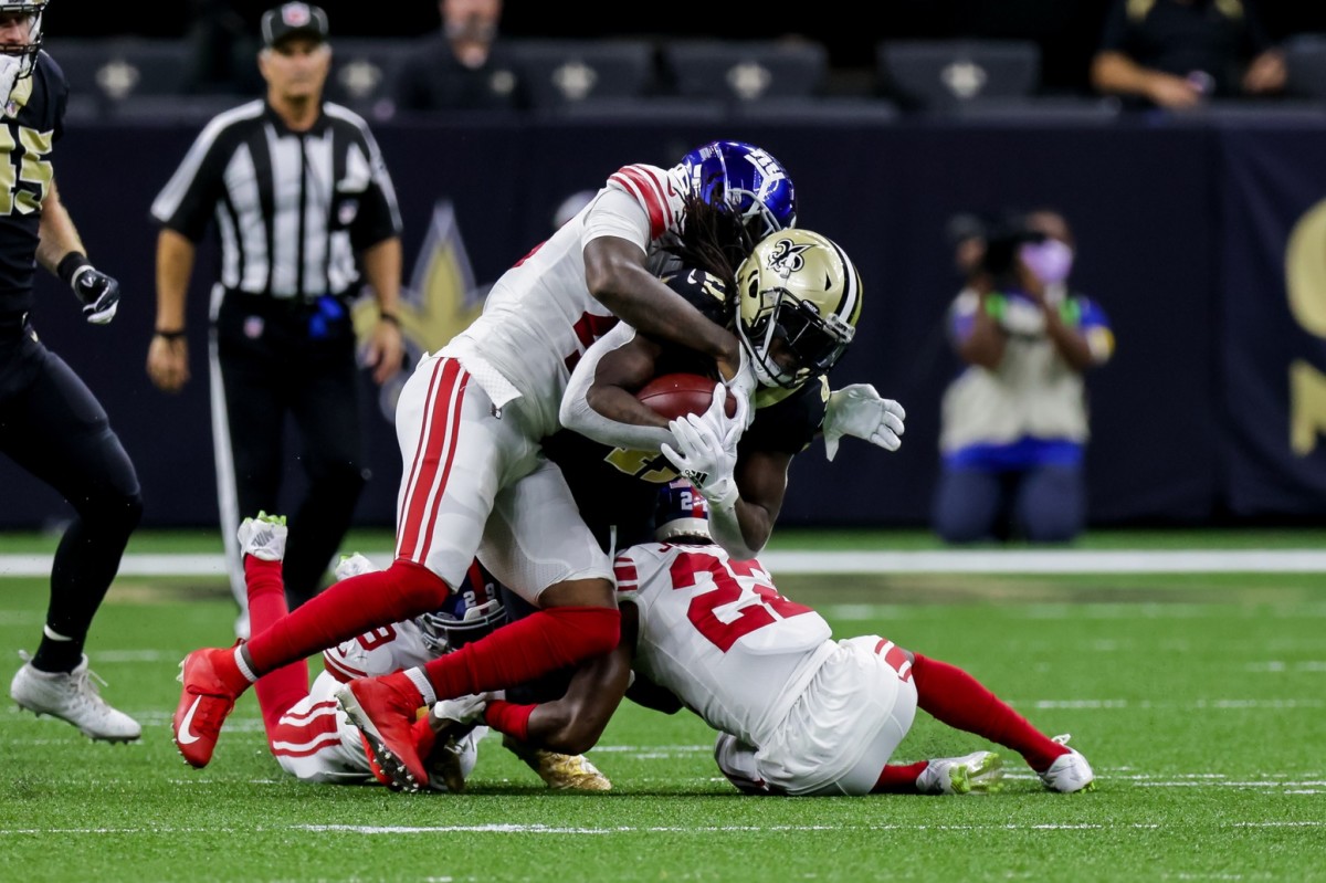 Oct 3, 2021; New Orleans, Louisiana, USA; New Orleans Saints running back Alvin Kamara (41) is tackled by New York Giants cornerback Logan Ryan (23) during the first half at Caesars Superdome.
