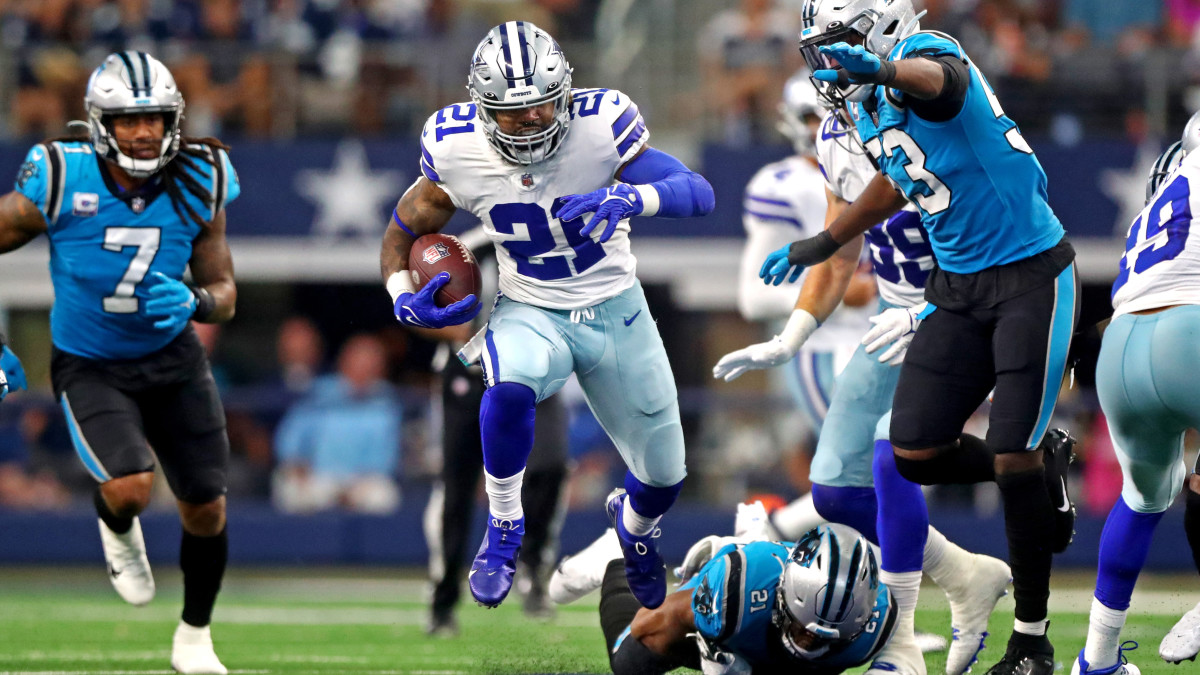 Dallas Cowboys running back Ezekiel Elliott (21) runs the ball against Carolina Panthers defensive end Brian Burns (53) during the second half at AT&T Stadium.