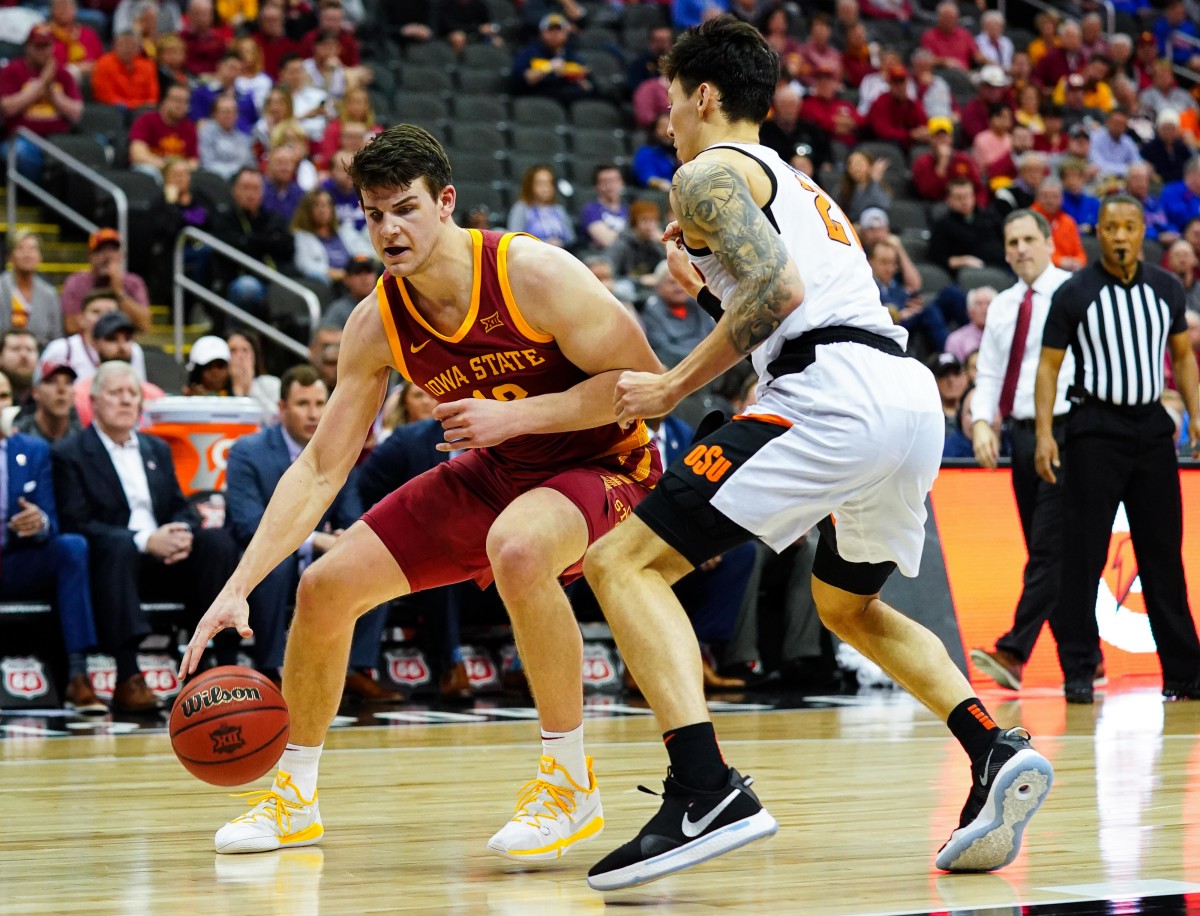 Mar 11, 2020; Kansas City, Missouri, USA; Iowa State Cyclones forward Michael Jacobson (12) dribbles against Oklahoma State Cowboys guard Lindy Waters III (21) during the first half at Sprint Center.