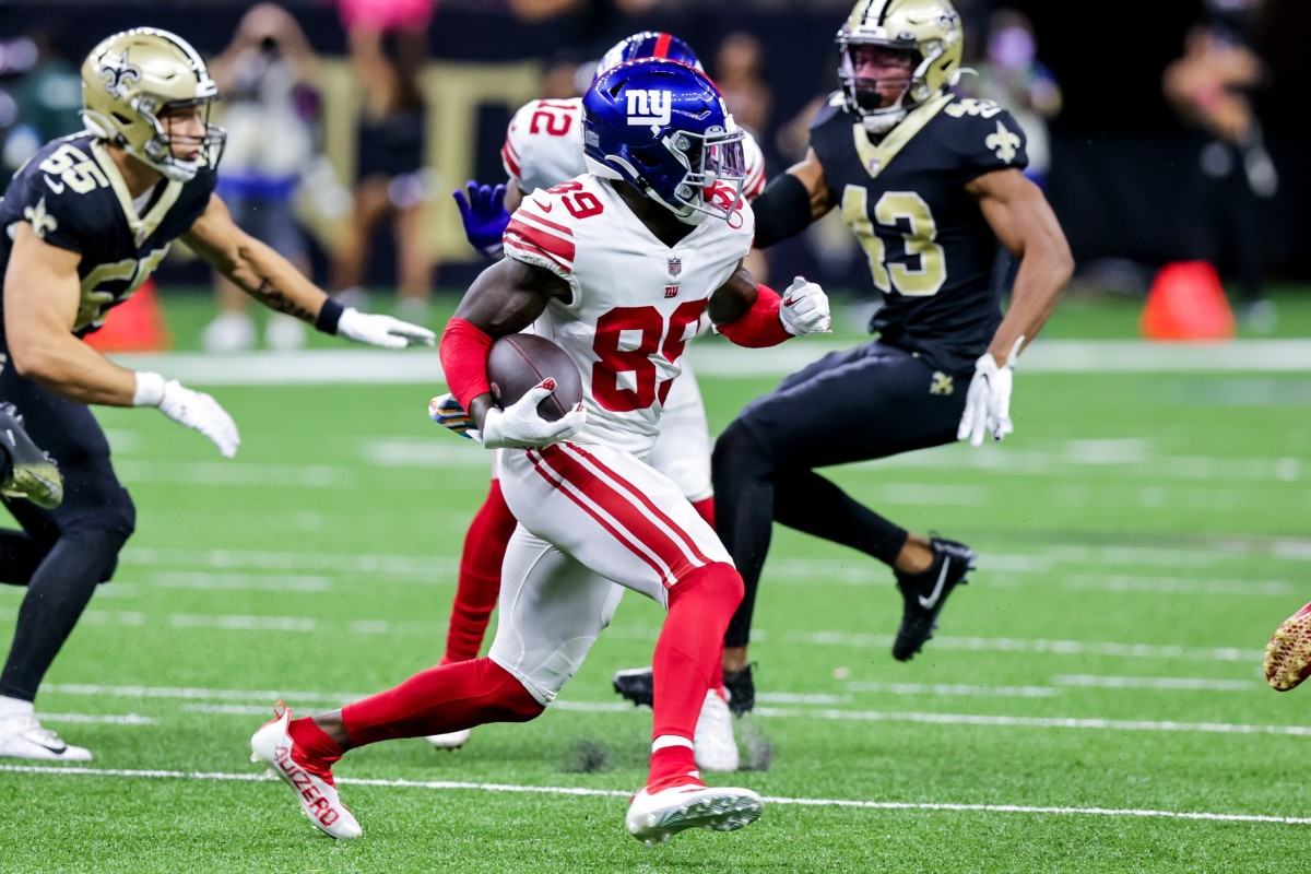 Oct 3, 2021; New Orleans, Louisiana, USA; New York Giants wide receiver Kadarius Toney (89) runs from the tackle of New Orleans Saints linebacker Kaden Elliss (55) during the first half at Caesars Superdome.