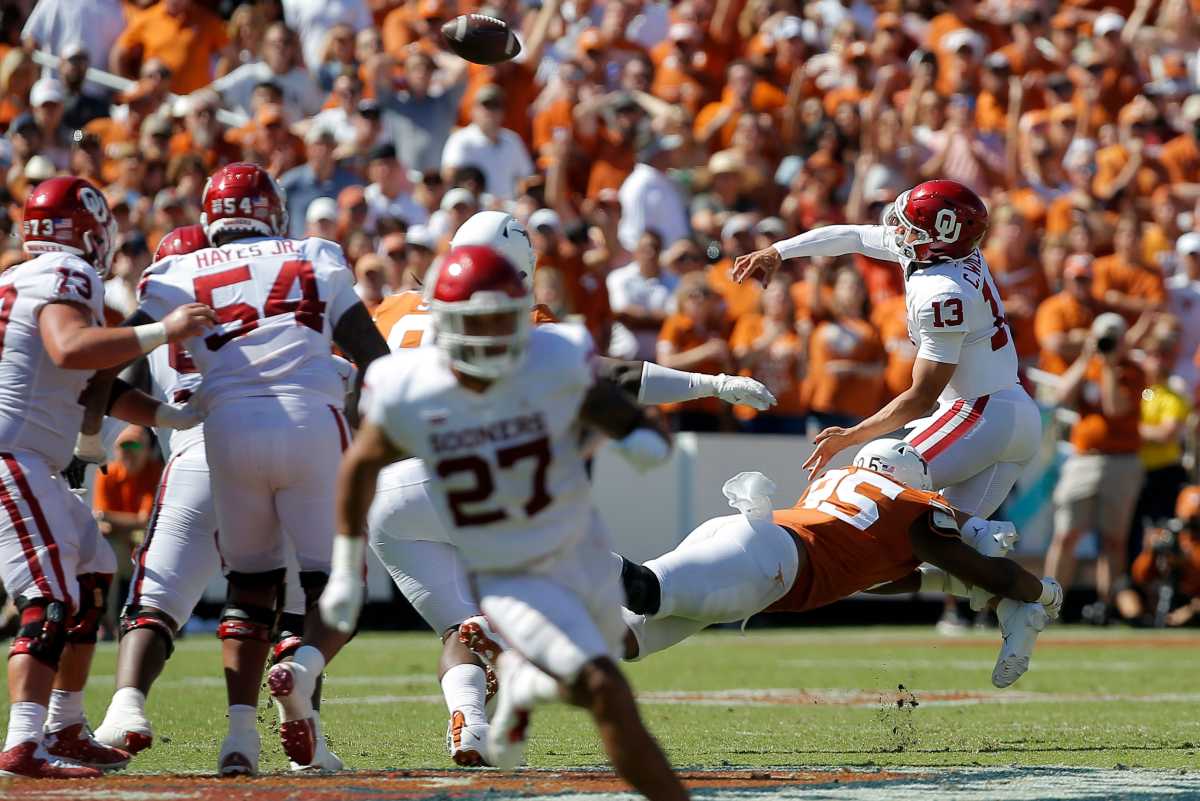 Oklahoma's Caleb Williams (13) is hit by Texas's Alfred Collins (95) as he throws a pass during the Red River Showdown college football game between the University of Oklahoma Sooners (OU) and the University of Texas (UT) Longhorns at the Cotton Bowl in Dallas, Saturday, Oct. 9, 2021. Oklahoma won 55-48. Ou Vs Texas