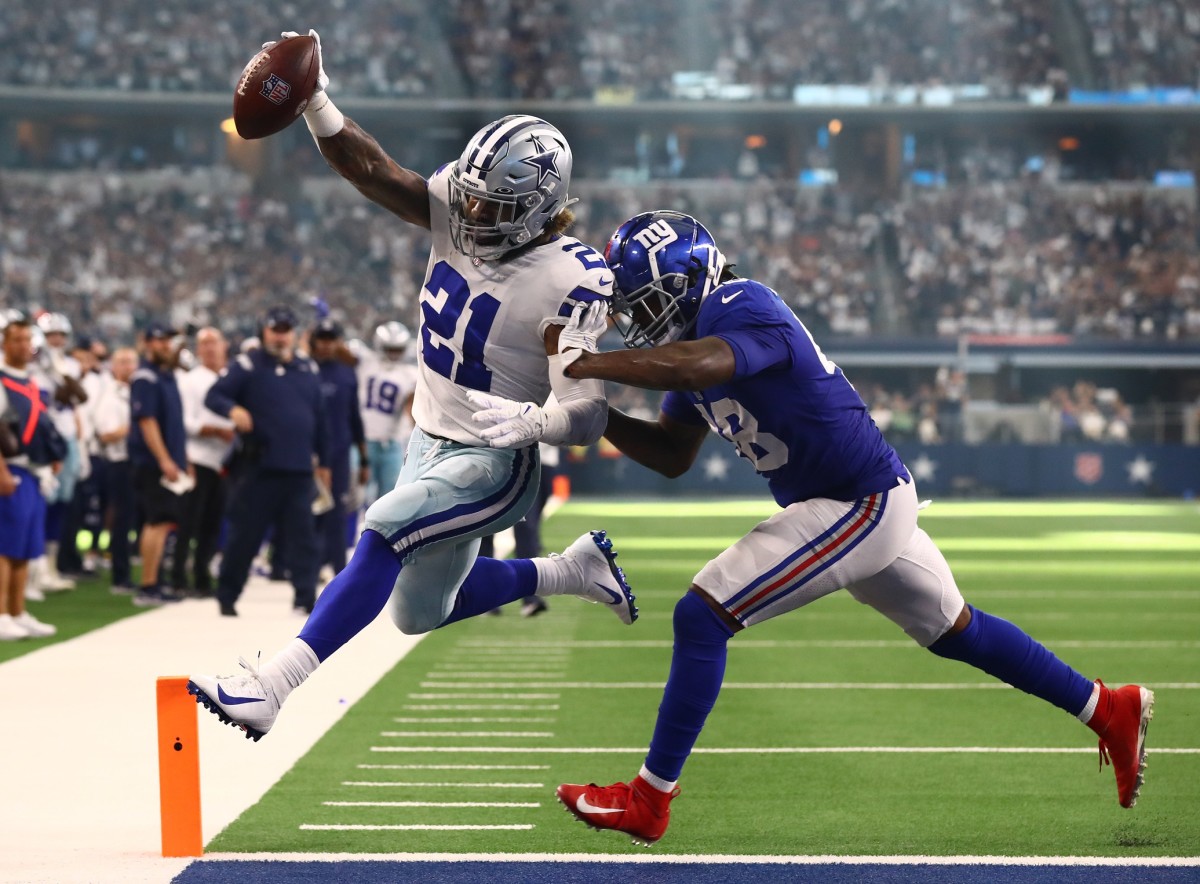 Oct 10, 2021; Arlington, Texas, USA; Dallas Cowboys running back Ezekiel Elliott (21) scores a third quarter touchdown against New York Giants linebacker Tae Crowder (48) at AT&T Stadium.