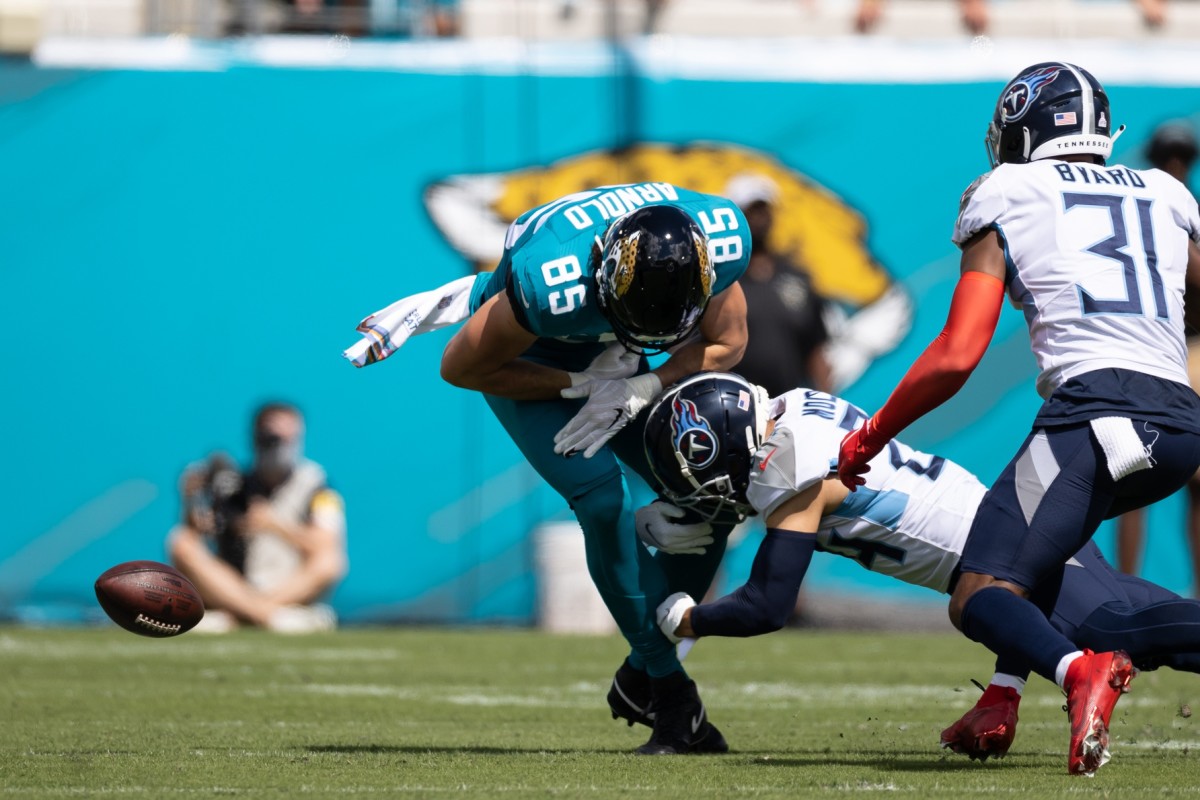 Jacksonville, Florida, USA; Jacksonville Jaguars tight end Dan Arnold (85) loses the ball after a hit from Tennessee Titans cornerback Elijah Molden (24) during the first quarter at TIAA Bank Field.