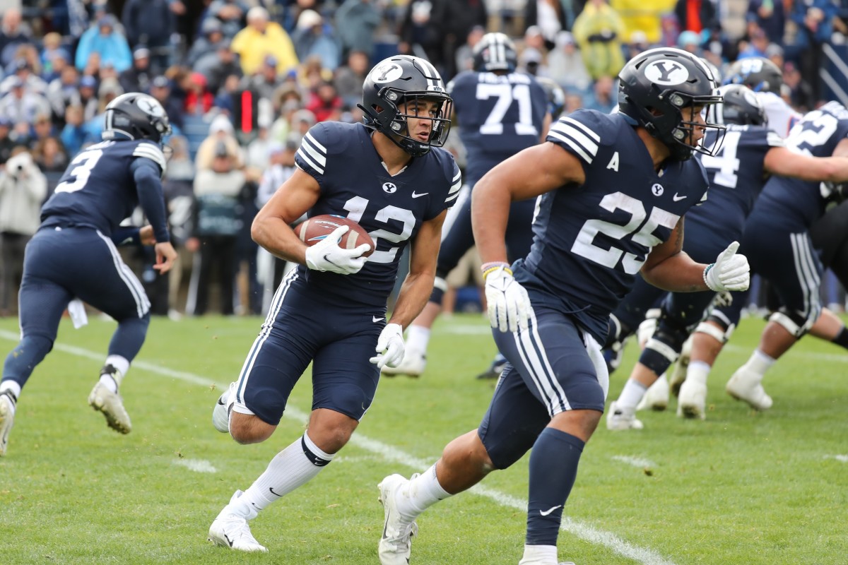 Byu football uniforms with the jersey being royal blue and side stripes  cougar tan. the helmets are cougar tan with a royal blue block cougar logo  on Craiyon