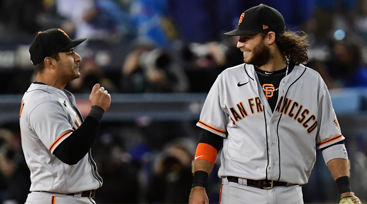 San Francisco Giants shortstop Brandon Crawford (35) and second baseman Donovan Solano (7) celebrate after defeating the Los Angeles Dodgers in game three of the 2021 NLDS at Dodger Stadium.