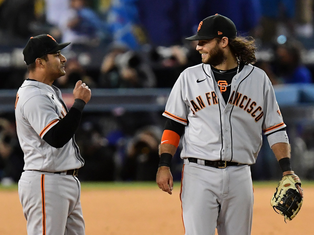San Francisco Giants shortstop Brandon Crawford (35) and second baseman Donovan Solano (7) celebrate after defeating the Los Angeles Dodgers in game three of the 2021 NLDS at Dodger Stadium.