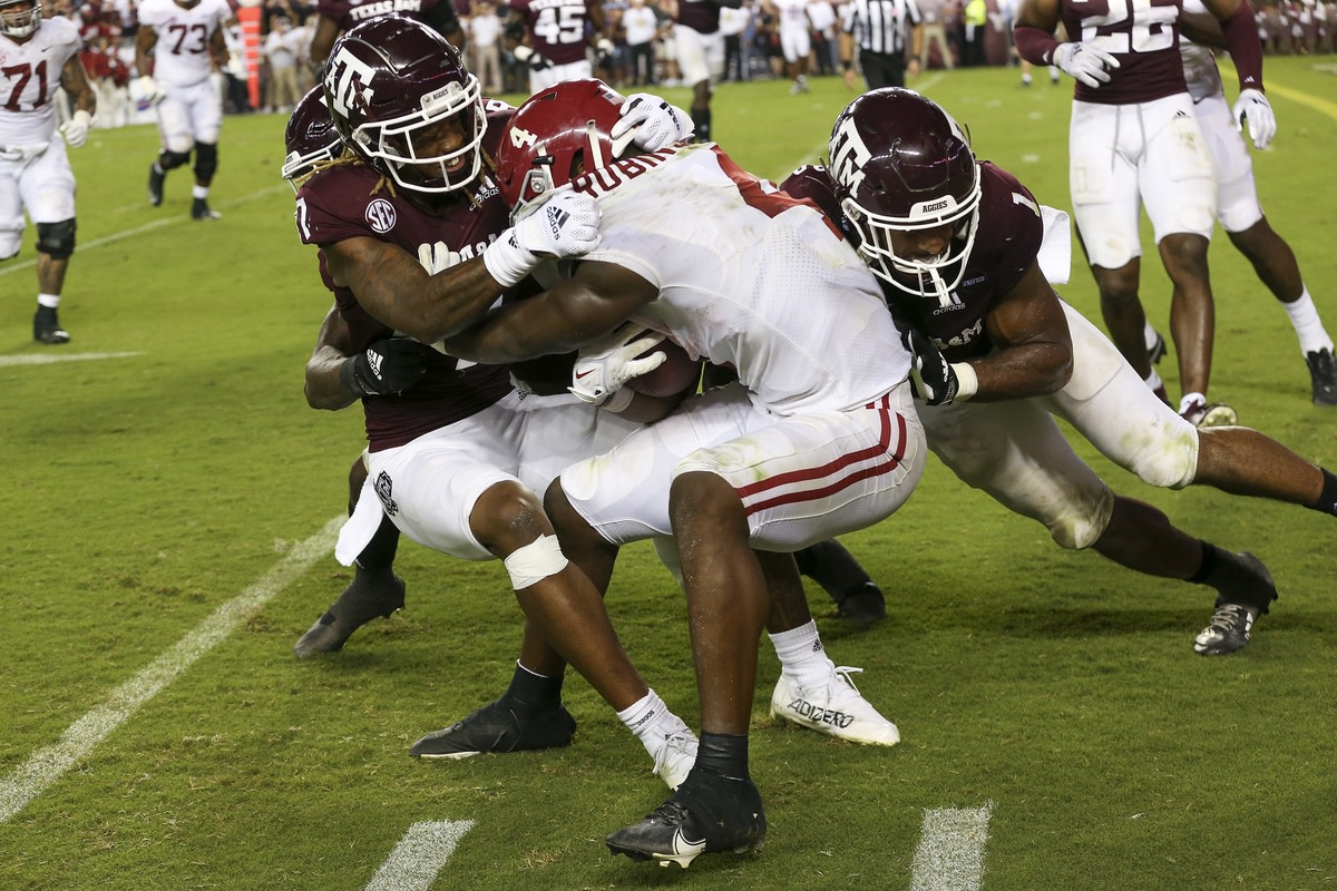 Oct 9, 2021; College Station, Texas, USA; Alabama Crimson Tide running back Brian Robinson Jr. (4) is tackled Texas A&amp;M Aggies defensive back Tyreek Chappell (7) and linebacker Aaron Hansford (1) in the second half at Kyle Field. Mandatory Credit: Thomas Shea-USA TODAY Sports