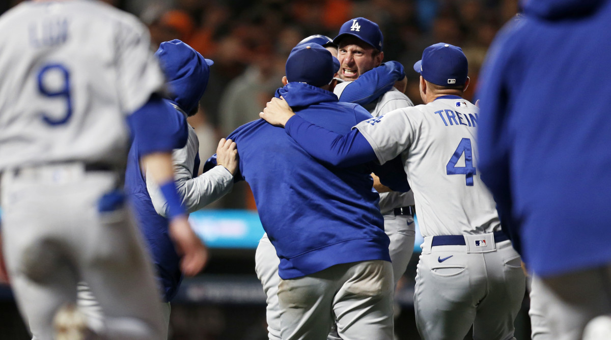 Oct 14, 2021; San Francisco, California, USA; Los Angeles Dodgers pitcher Max Scherzer (facing camera) is mobbed by teammates after defeating the San Francisco Giants in game five of the 2021 NLDS at Oracle Park.