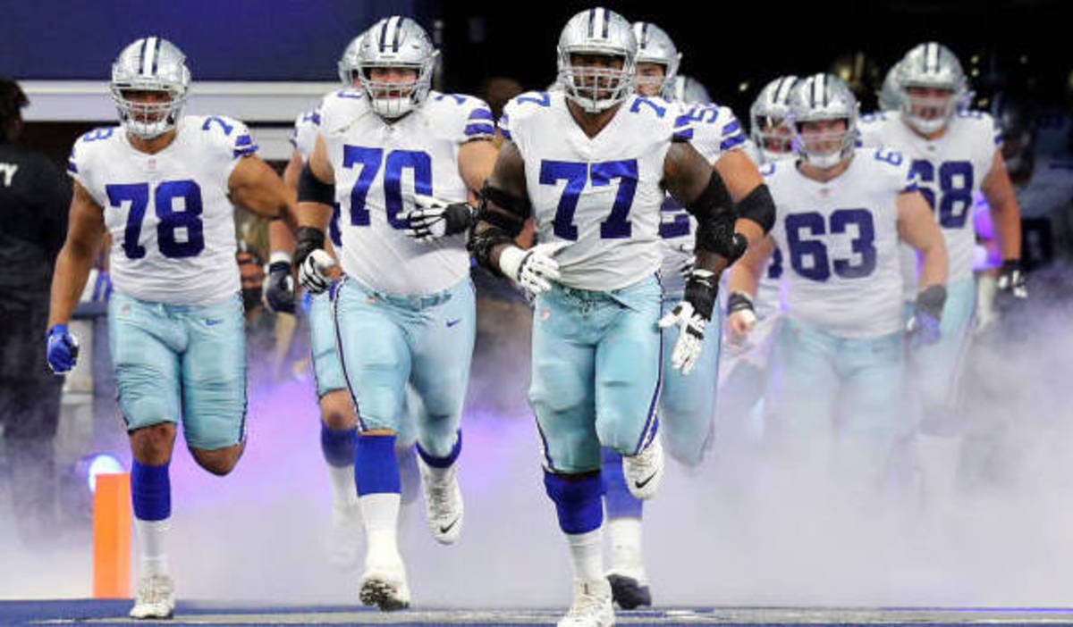 ARLINGTON, TEXAS - OCTOBER 03: Terence Steele #78, Zack Martin #70, and Tyron Smith #77 of the Dallas Cowboys lead the team on to the field before the game against the Carolina Panthers at AT&T Stadium on October 03, 2021 in Arlington, Texas. (Photo by Richard Rodriguez/Getty Images)
