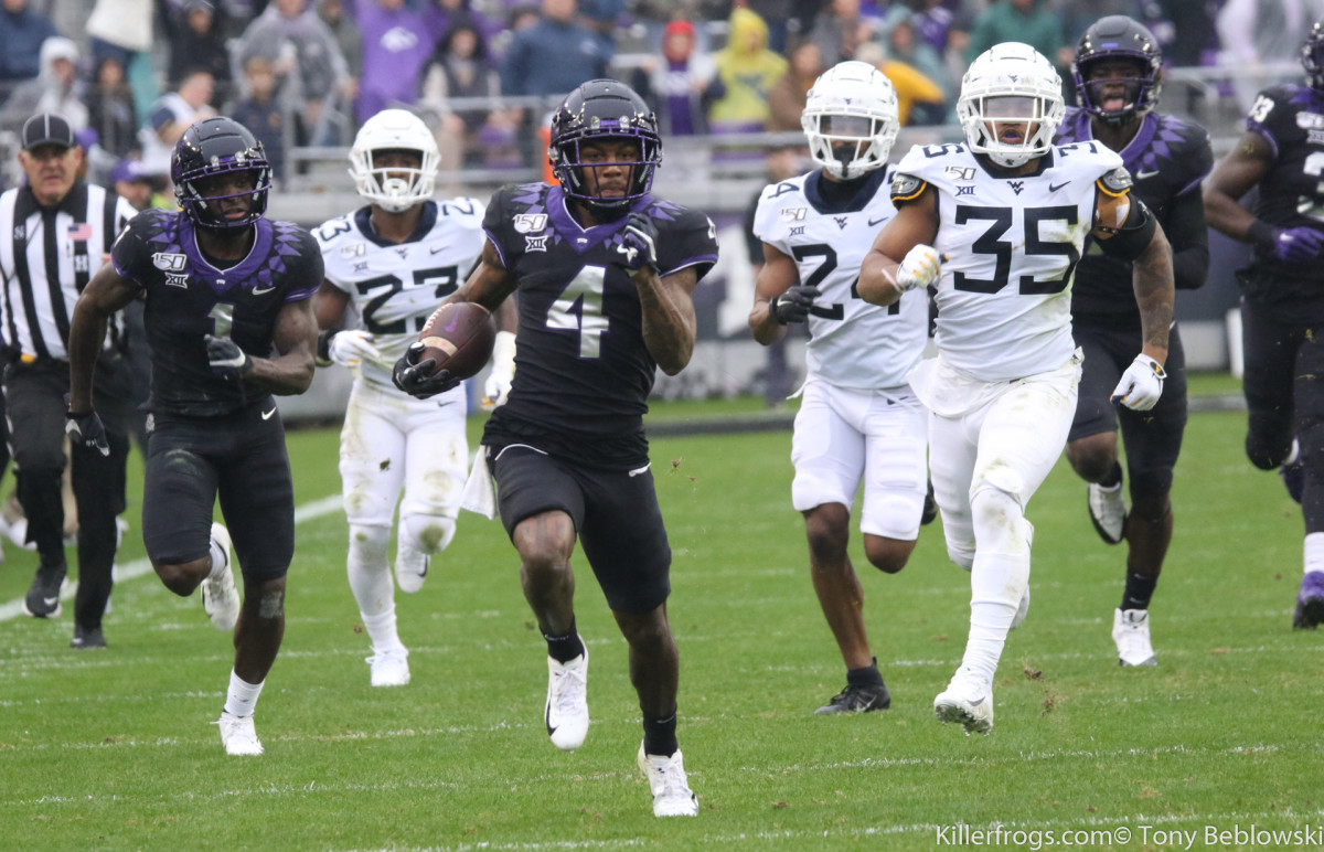 TCU wide receiver Taye Barber runs away from West Virginia defenders in the 2019 game in Fort Worth.