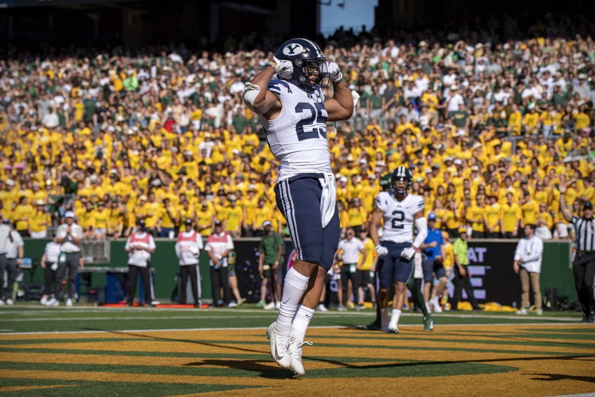 Byu football uniforms with the jersey being royal blue and side stripes  cougar tan. the helmets are cougar tan with a royal blue block cougar logo  on Craiyon