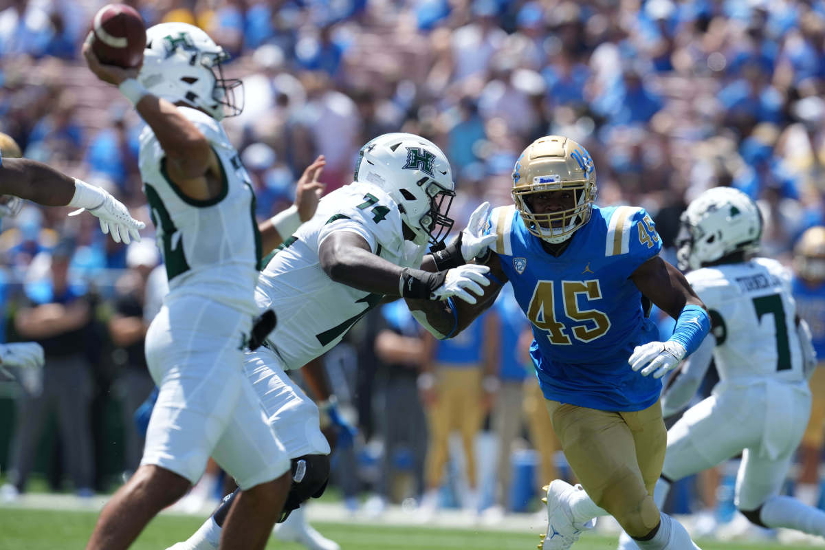 UCLA linebacker Mitchell Agude (45) is defended by Hawaii offensive lineman Gene Pryor (74).