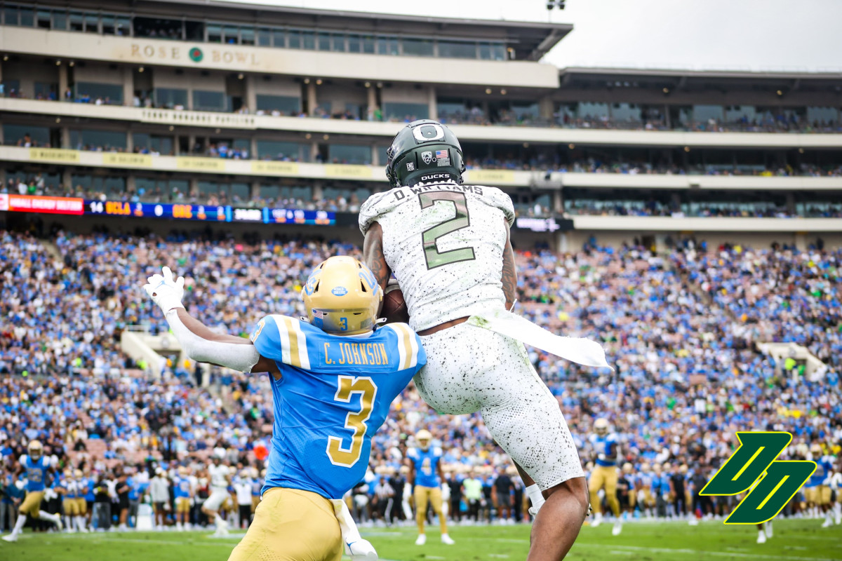 Devon Williams (2) rises up for a contested catch on UCLA's Caleb Johnson (3).