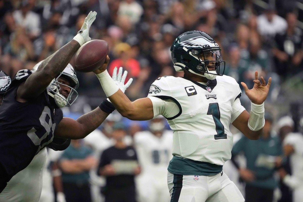 Jalen Hurts under pressure from the Raiders defense and the Eagles fan base