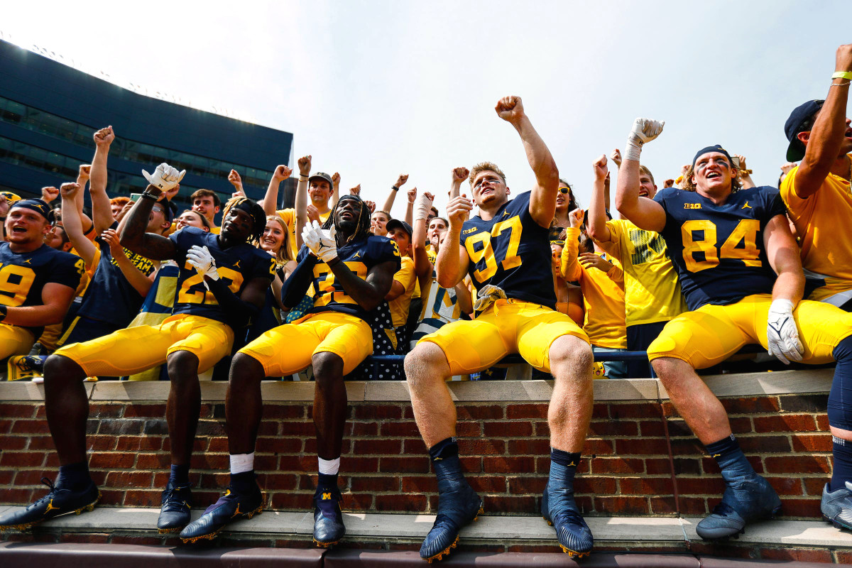 Michigan football players celebrate after a 2021 win