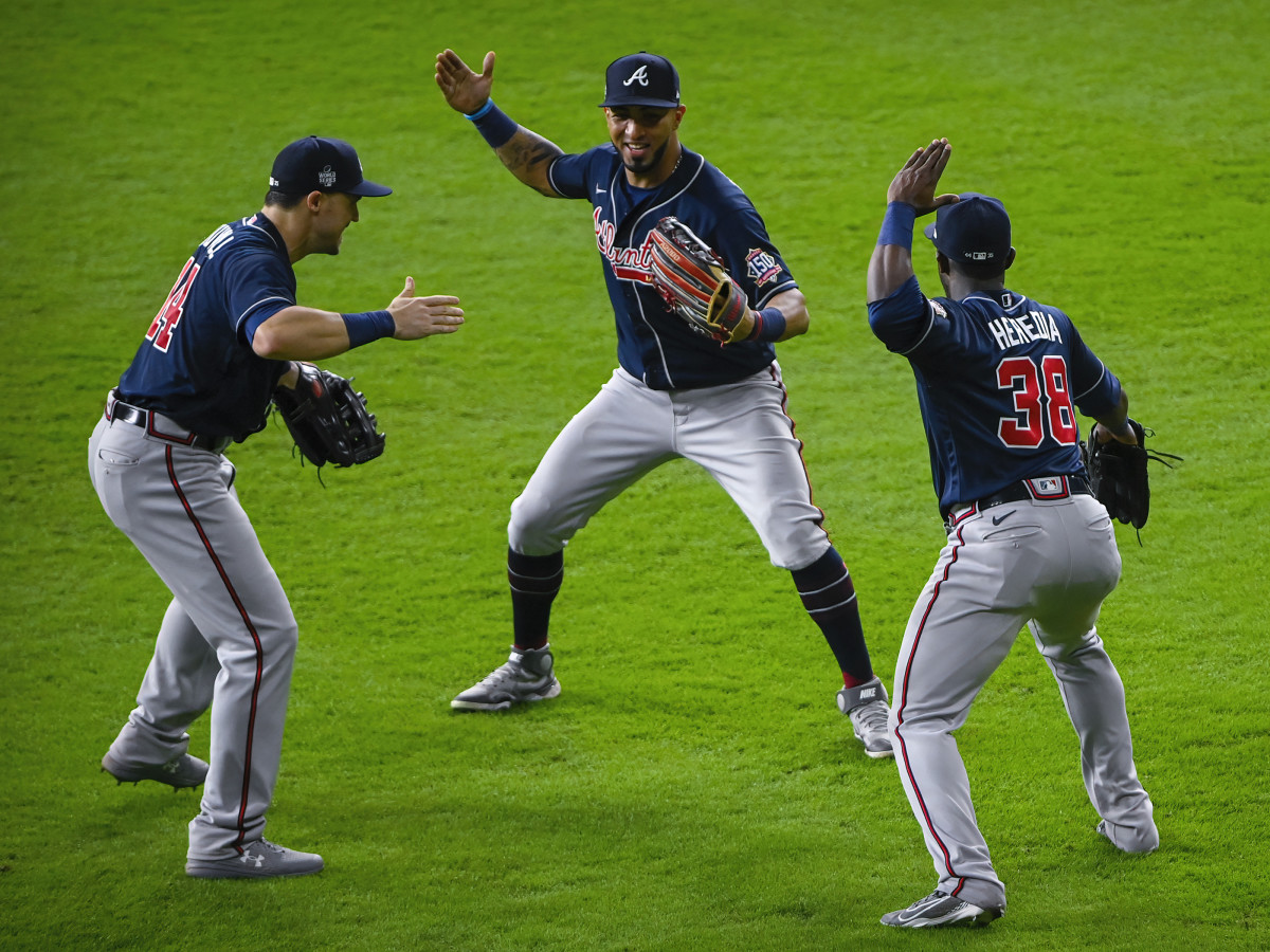 Atlanta Braves center fielder Adam Duvall (14) and left fielder Eddie Rosario (8) and center fielder Guillermo Heredia (38) celebrate the win over the Houston Astros in game one of the 2021 World Series.