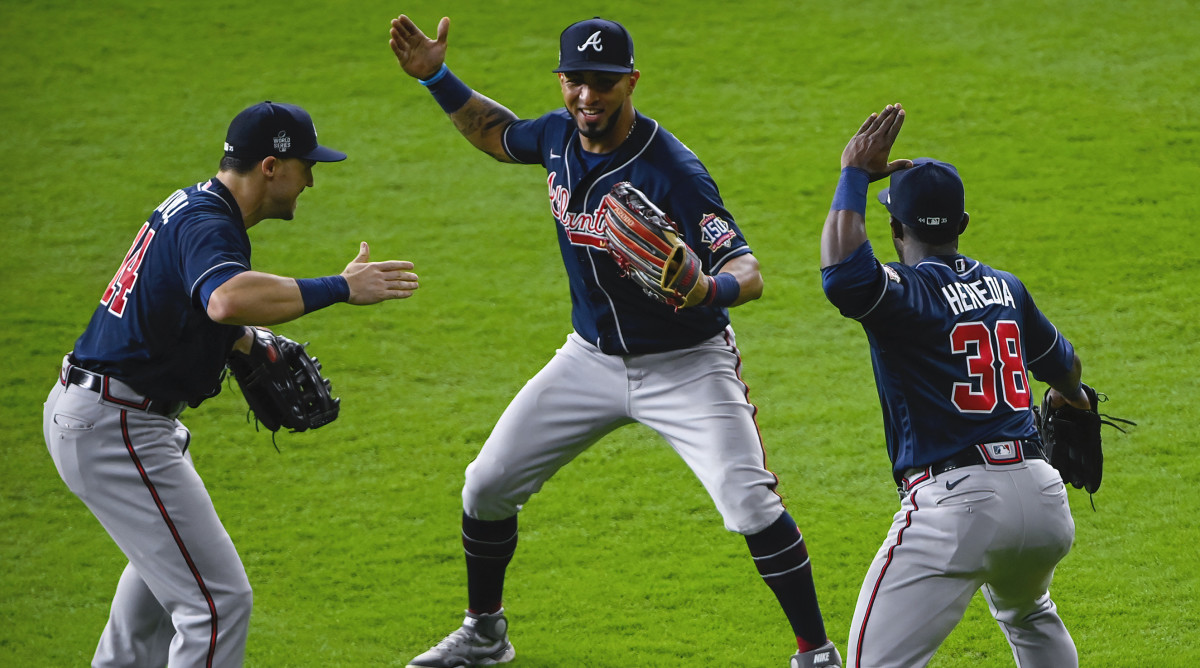 Atlanta Braves center fielder Adam Duvall (14) and left fielder Eddie Rosario (8) and center fielder Guillermo Heredia (38) celebrate the win over the Houston Astros in game one of the 2021 World Series.