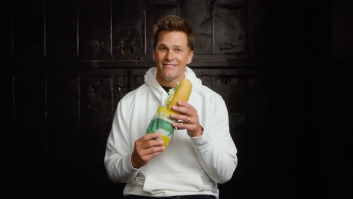 Tom Brady holding a Subway sub up to his mouth