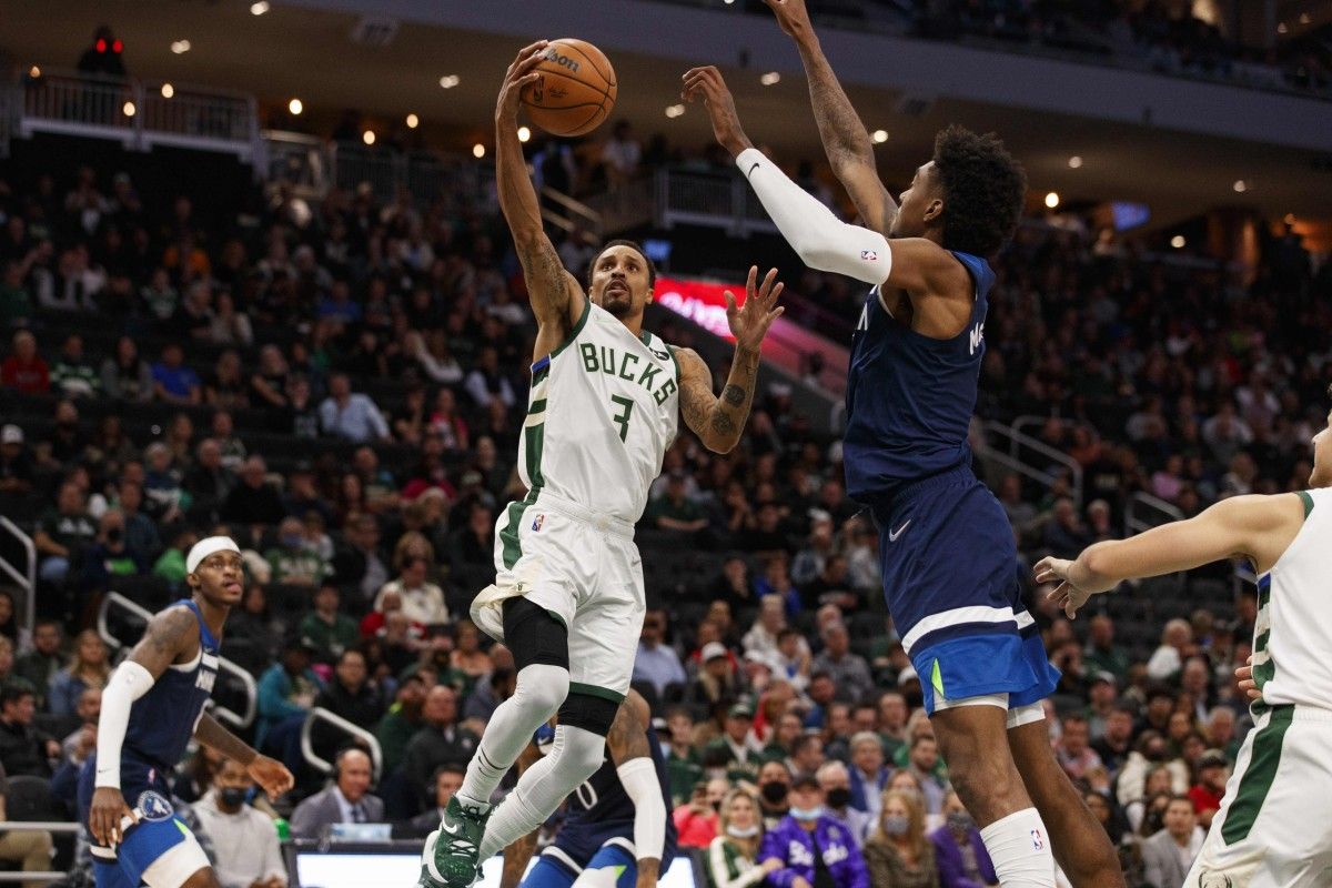 Jaden McDaniels tries to stop the Bucks' George Hill.