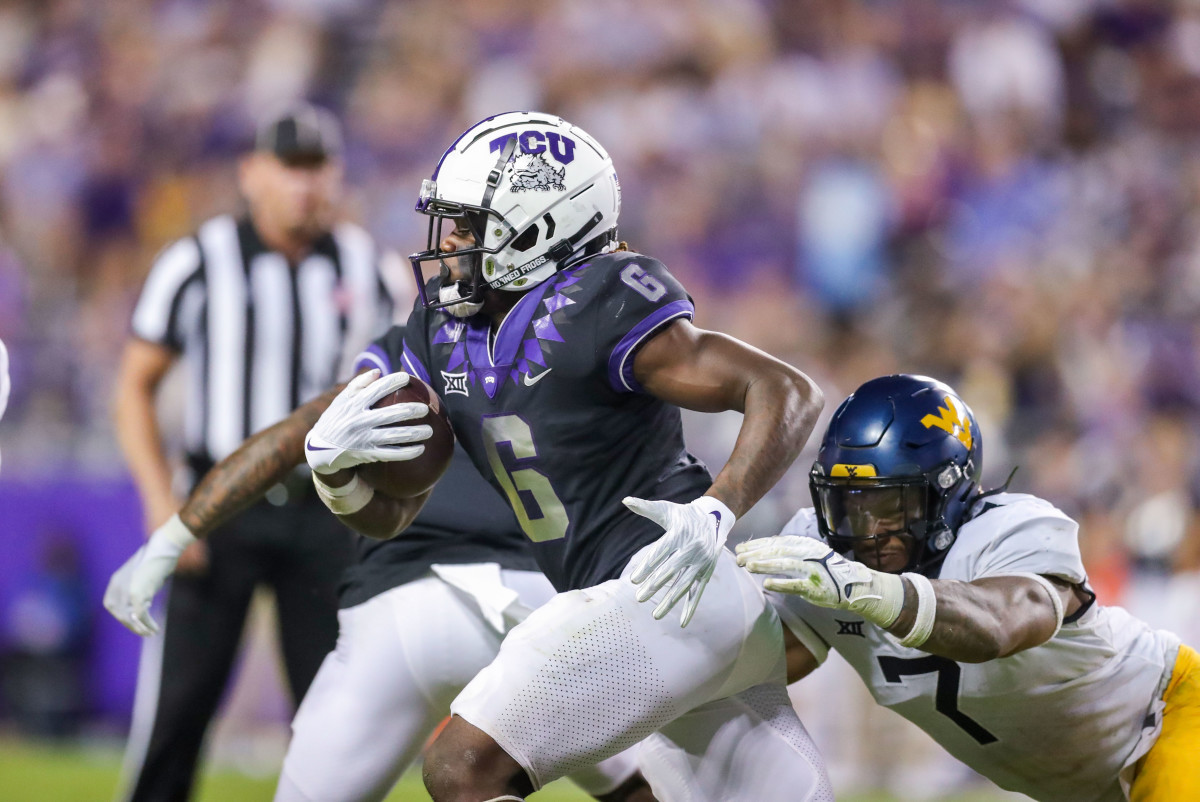 Oct 23, 2021; Fort Worth, Texas, USA; TCU Horned Frogs running back Zach Evans (6) runs the ball while being tackled by West Virginia Mountaineers linebacker Josh Chandler-Semedo (7) during the third quarter at Amon G. Carter Stadium.