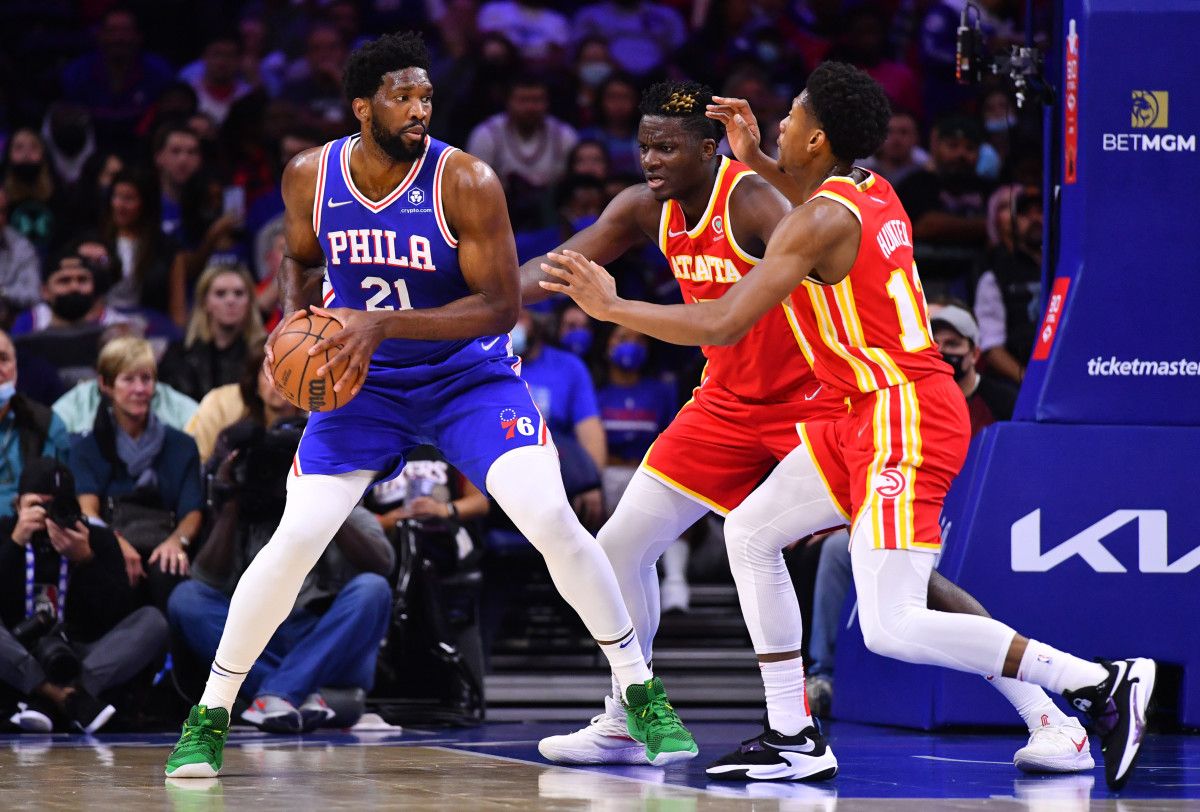 Philadelphia 76ers center Joel Embiid (21) controls the ball against Atlanta Hawks center Clint Capela (15) and forward De'Andre Hunter (12) in the first quarter at Wells Fargo Center.