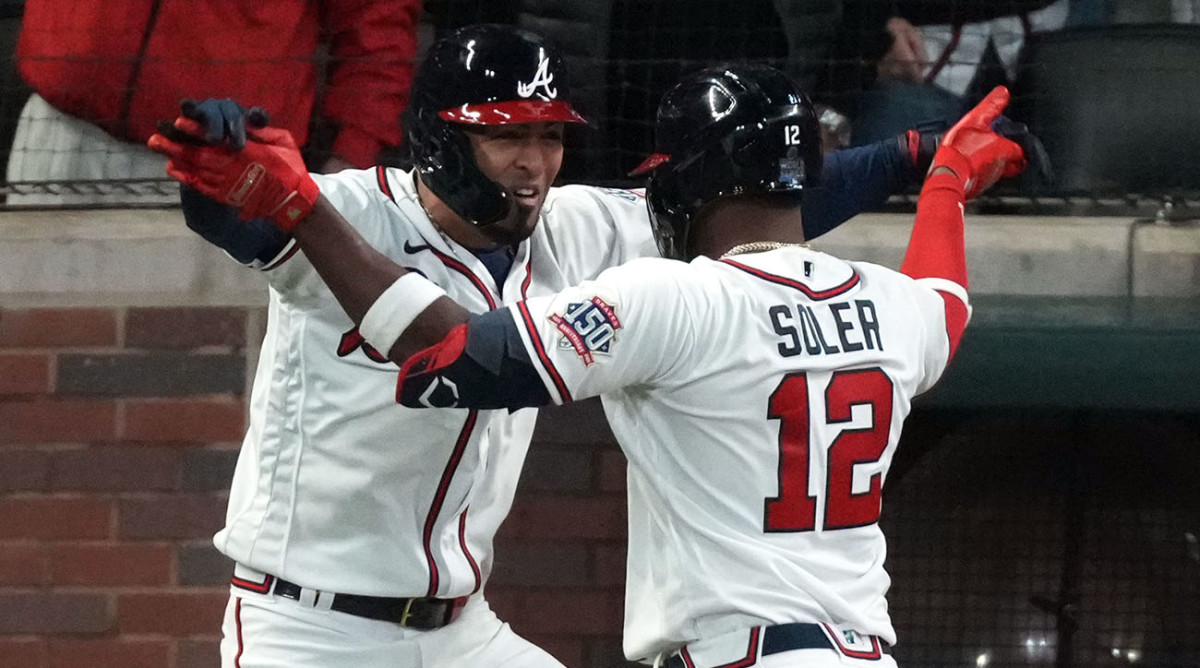 Atlanta Braves designated hitter Jorge Soler (12) celebrates with left fielder Eddie Rosario (8) after hitting a home run against the Houston Astros during the seventh inning of World Series Game 4.