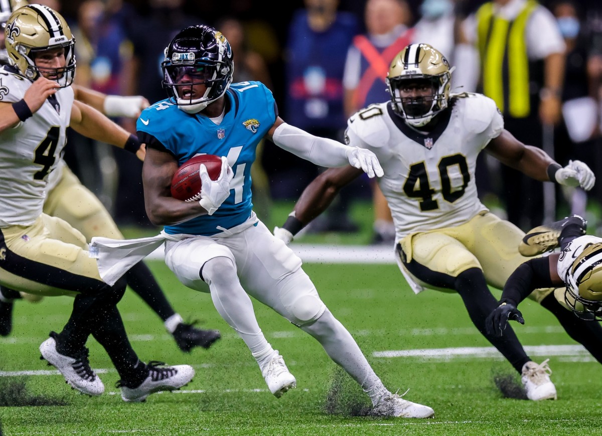 Aug 23, 2021; New Orleans, Louisiana, USA; Jacksonville Jaguars wide receiver Pharoh Cooper (14) runs the ball against New Orleans Saints fullback Alex Armah (40) during the second half at Caesars Superdome.