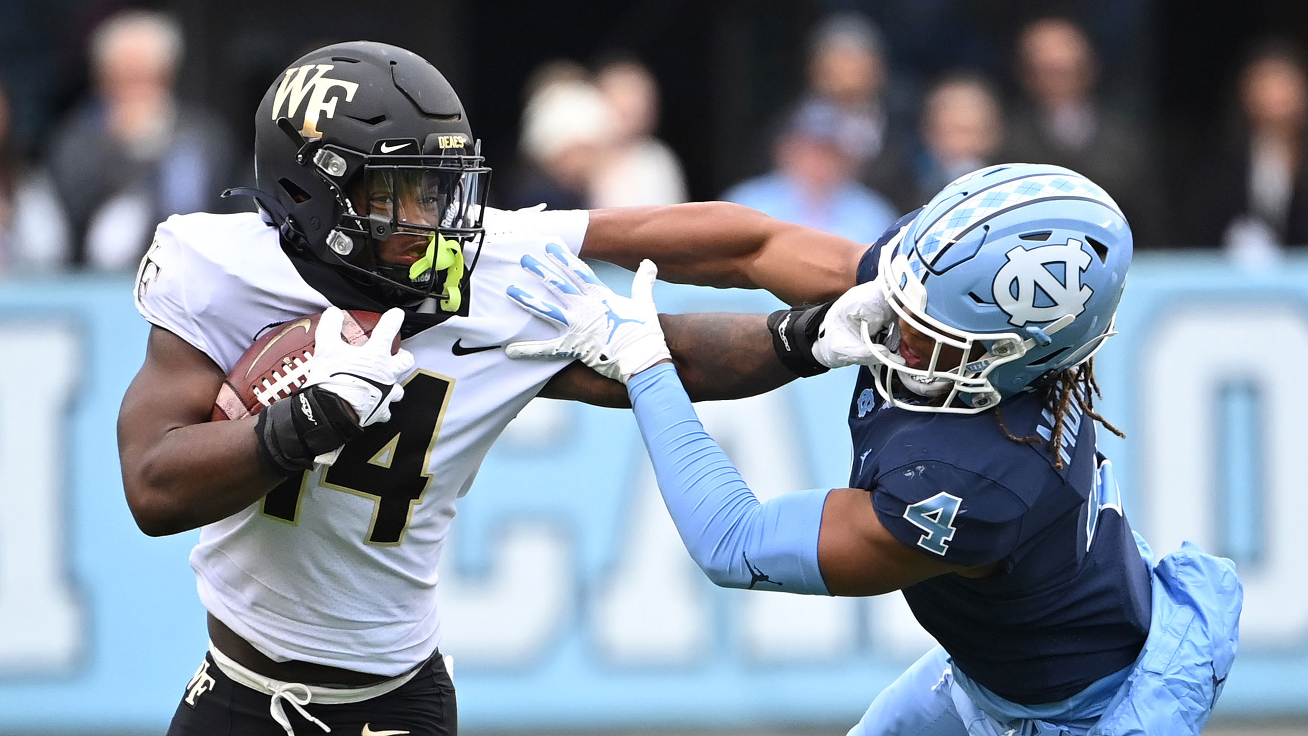 Wake Forest's Ryan Dupont holds a UNC defender at arm's length