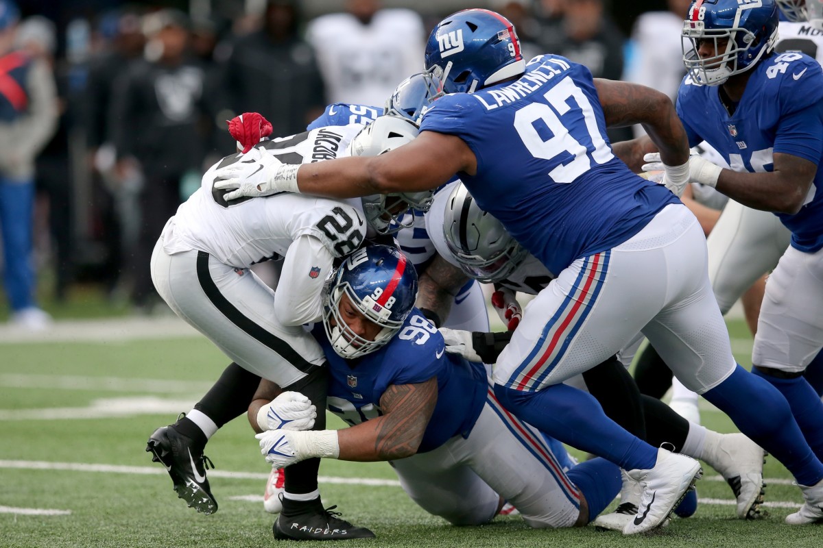 Nov 7, 2021; East Rutherford, New Jersey, USA; Las Vegas Raiders running back Josh Jacobs (28) is tackled by New York Giants nose tackle Austin Johnson (98) and defensive tackle Dexter Lawrence (97) during the third quarter at MetLife Stadium.