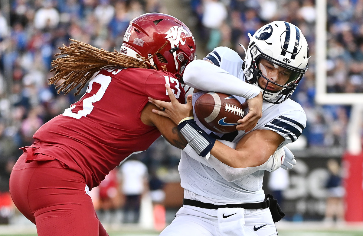 Washington State Cougars linebacker Jahad Woods (13) tries to strip the ball away from Brigham Young Cougars quarterback Jaren Hall (3).